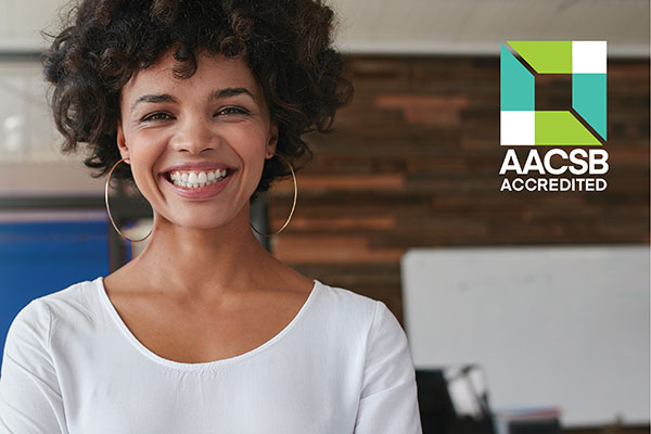 businesswoman smiling with AACSB logo to the side